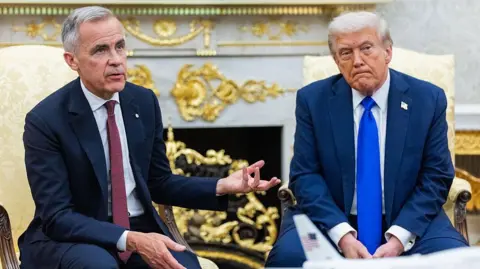 Getty Images Photo of Canadian Prime Minister Mark Carney next to US President Donald Trump on the right speaking at the White House's Oval Office