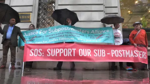 PA Media Campaigners outside Aldwych House, central London, where the Post Office Horizon IT inquiry is taking place - they are holding up two banners, a blue one with the text Justice for subpostmasters alliance - and a second red one with SOS: Support our Sub-postmasters written on it 