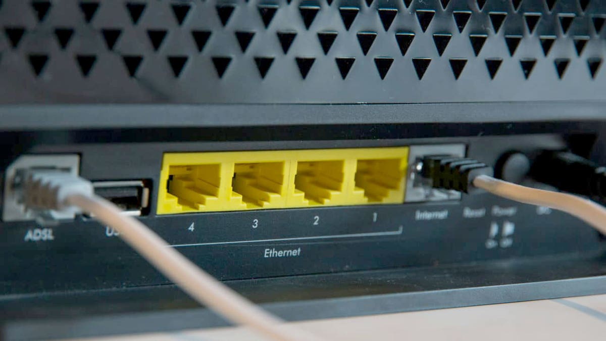 Close-up of a Wi-Fi router showing Ethernet ports and connected network cables.